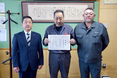 写真：山田校長（左）から感謝状を受け取った緑豊建設の工事担当者