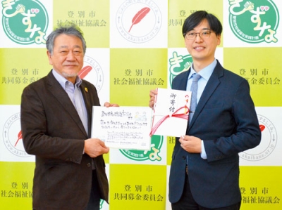 写真：仲川会長に寄付金を手渡す髙橋牧師（左）