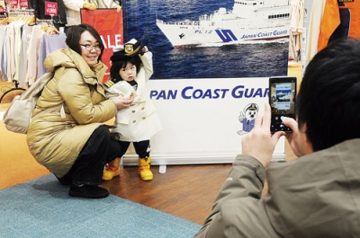 写真：海保の制服を着て記念撮影する親子
