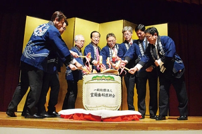 写真：「よいしょ」のかけ声で、たる酒の鏡開きを行う室蘭歯科医師会の関係者