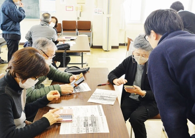 写真：市職員から市公式ＬＩＮＥの登録方法などを教わる参加者たち