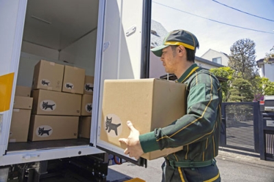 写真:車両から荷物を取り出すヤマト運輸の配達員(同社提供)