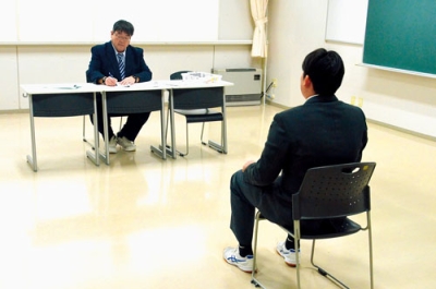 写真：面接官の質問に答える受験生（右）
