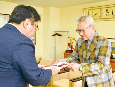 写真：小笠原市長に目録を手渡す内山社長（右）