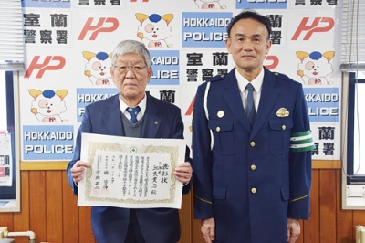 写真：表彰状を手にする江良さん（左）