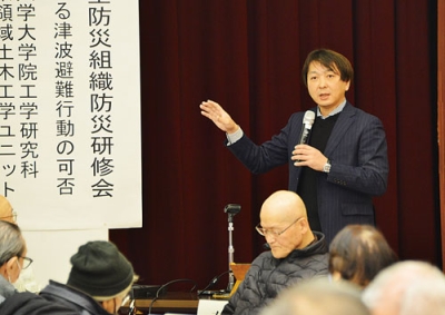 写真：車避難のアンケート結果や課題について講演する有村教授