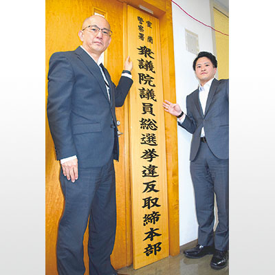 写真:取締本部の看板を設置する室蘭署員