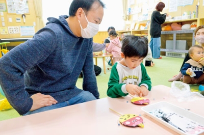 写真：でんでん太鼓に貼る鬼の顔をつくる子ども