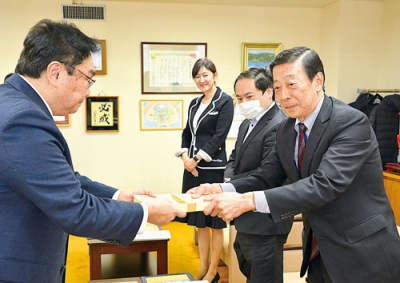 写真：小笠原市長に優待券を手渡す右から中牧組合長、岩井、南両副組合長