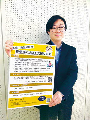 写真：医療、福祉分野の奨学金返還支援事業をＰＲするポスターを手にする伊達市職員