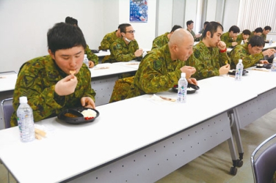 写真：ホッキカレーを味わう協力隊員