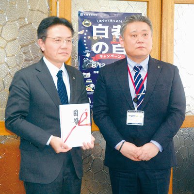 写真：目録を手渡した石見課長（右）と大塩町長