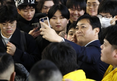 写真：街頭演説に集まった人たちと写真を撮る国民民主党の玉木代表＝２８日、大阪市