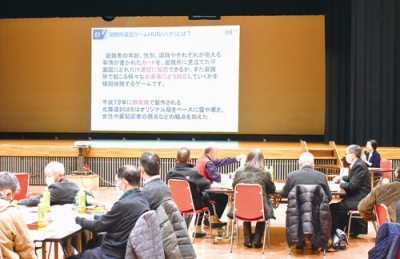 写真:避難所運営ゲーム「Doはぐ」について説明を受ける自治会役員たち