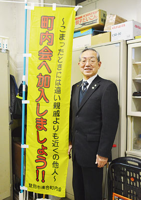 写真：町内会加入を呼びかける啓発のぼりを持つ工藤会長