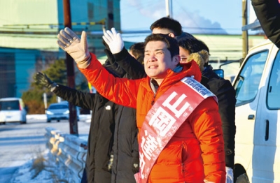 写真:室蘭市内の企業の前で支持者に手を振る山岡候補