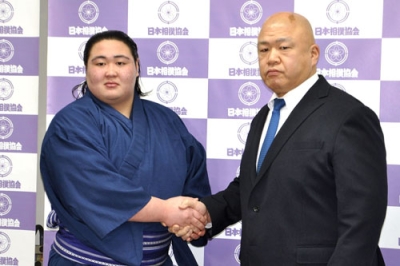 写真：新十両昇進が決まり、師匠の藤島親方（右）と握手する福崎改め藤天晴＝１月、両国国技館