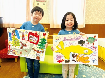 写真：作品を手に受賞を喜ぶ神谷空来ちゃん（左）と鈴木花朋ちゃん