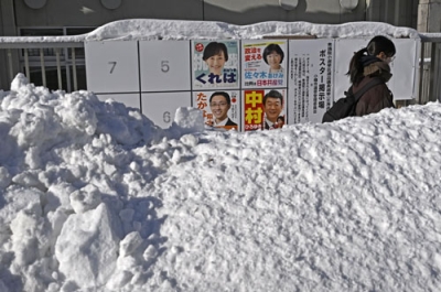 写真：雪の中に立つ衆院選のポスター掲示板。手前の道路には人の背丈ほどの高さに雪が積み上げられていた＝８日午前、小樽市