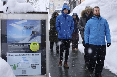 写真：スキー場を訪れる外国人観光客らでにぎわい、英語の看板が立つニセコエリア＝倶知安町