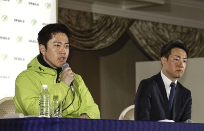 写真：大阪府知事選で３回目の当選を決め、記者会見する吉村洋文氏。右は大阪市長選で再選を決めた横山英幸氏＝８日夜、大阪市内のホテル