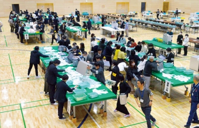 写真：有権者が思いを託した票を仕分ける開票作業の従事者＝８日夜、室蘭市の栗林商会アリーナ