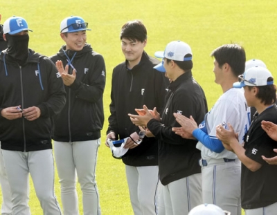 写真：キャンプに合流し、練習開始前に拍手で迎えられる日本ハム・有原（左から３人目）＝名護
