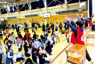 写真：餅まきを楽しむ児童・生徒たち（提供写真）