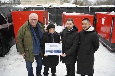 写真：日本がウクライナに供与した発電機の前に並ぶ（右から）服部修ＪＩＣＡウクライナ事務所長、エネルギー省のアナトリー・クツェボル副大臣、中込正志駐ウクライナ大使＝１１日、キーウ（共同）