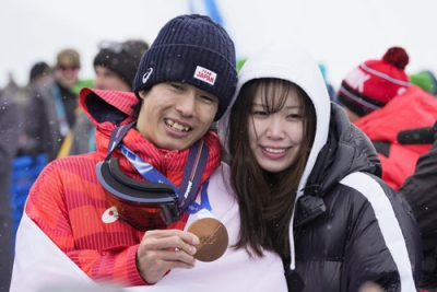 写真：男子モーグルで銅メダルを獲得し、妻の住吉輝紗良さん（右）と笑顔を見せる堀島行真＝リビーニョ（共同）