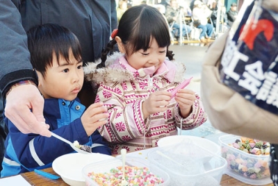 写真:デコレーション用のチョコレートやトッピングを思い思いに選ぶ子どもたち