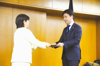 写真：大崎委員長から当選証書を受け取る松下氏