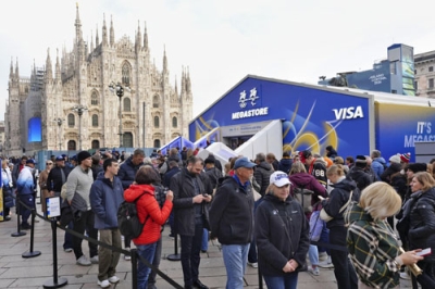 写真：ミラノ・コルティナ冬季五輪の公式グッズを販売する「メガストア」に並ぶ人たち。奥は大聖堂＝１２日、イタリア・ミラノ（共同）