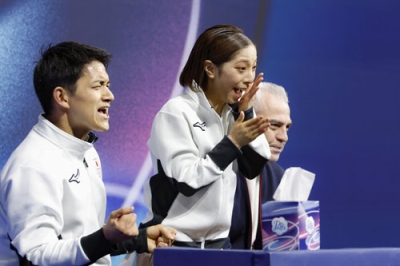 写真:フィギュアスケートペア・フリーの得点を確認し、喜びを爆発させる三浦璃来(中央)、木原龍一組=16日、イタリア・ミラノ(共同)