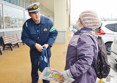 写真:買い物客に注意喚起する佐藤所長