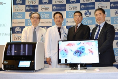 写真：細胞診自動判定システムの機器と写真に納まるがん研究会有明病院の千葉知宏細胞診断部部長（左から２人目）ら＝１８日午後、東京都江東区