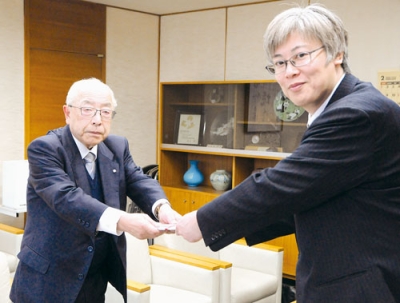 写真：目録を手渡す三上会長（左）