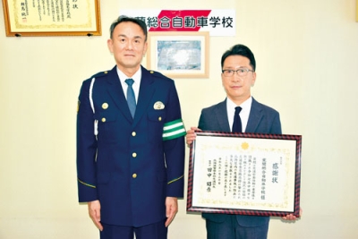 写真:交通安全活動に貢献したとして、感謝状を受け取った菊地校長(右)