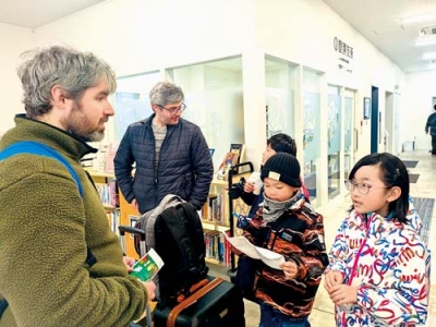 写真：訪日観光客へプレゼントを渡す子どもたち（提供写真）