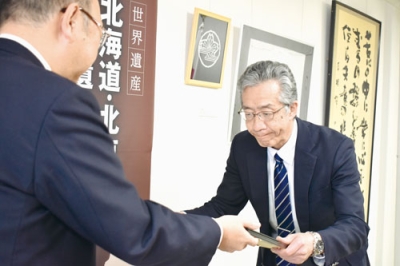 写真：教育向上への功績が認められ、表彰状を受け取る阿部校長（右）