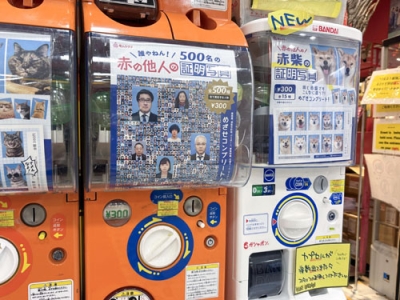 写真:カプセルトイ「赤の他人の証明写真」の自動販売機(中央)=東京都渋谷区