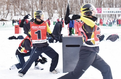 写真：スタートの合図とともに雪球を投げる選手たち