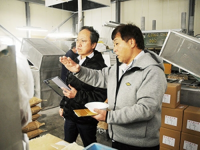 写真：三好製作所の魚戸社長（右）の案内で工場内を見て回る永井さん