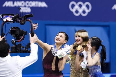 写真:フィギュアスケート女子の表彰式で自撮りする(左から)銀メダルの坂本花織、金のアリサ・リュウ、銅の中井亜美=19日、イタリア・ミラノ(共同)