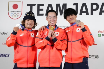 写真：記者会見でメダルを掲げるスノーボード男子の（左から）長谷川帝勝、木村葵来、木俣椋真＝２０日、イタリア・ミラノ（共同）