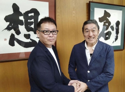 写真：学校法人「国際志学園」の水嶋章陽理事長（右）と握手する「ＭＭＡ甲子園」を主催する岩崎ヒロユキ代表＝２０２５年７月、北九州市