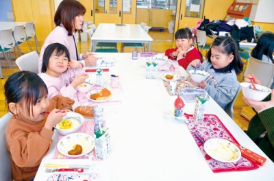 写真：初めての学校給食を味わう園児たち