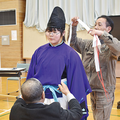 写真：伊達市仙台神楽保存会メンバーのサポートで、伝統衣装を試着する関内小児童