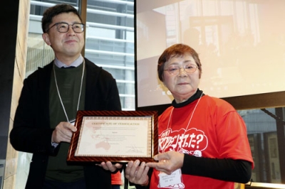 写真：風疹「排除」の認定書を持つ「風疹をなくそうの会」の可児佳代共同代表（右）と厚生労働省の鷲見学・感染症対策部長（左）＝東京都中央区