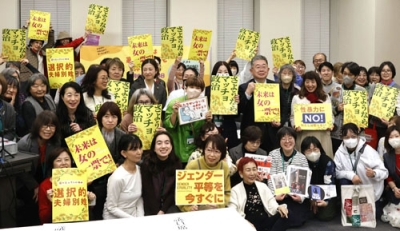 写真：集会で思いが記されたプラカードを手に記念撮影する女性ら＝国会